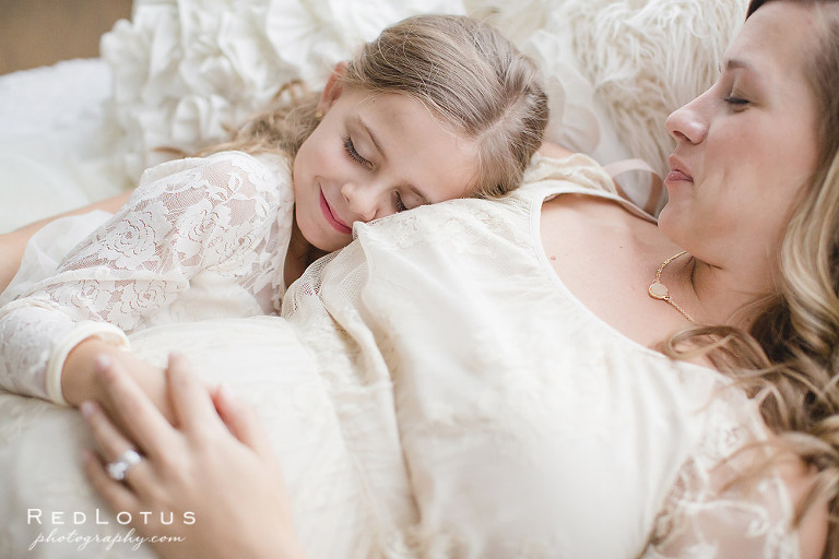 maternity photos mother and child laying in bed