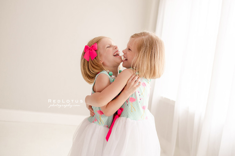 twin girls hugging laughing photo shoot studio