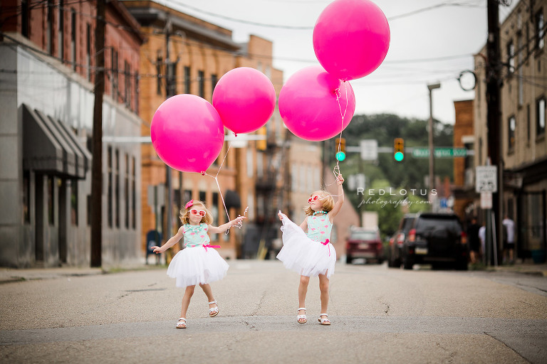 twin girls giant balloons urban photo session jumping dancing sunglasses tutus