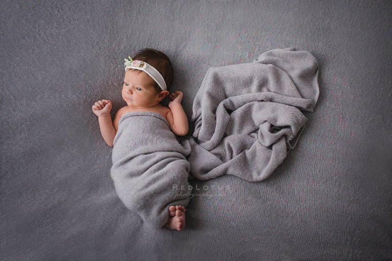 natural newborn pose baby eyes open laying on a beanbag