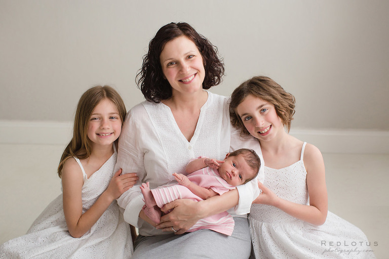newborn baby with mother and sisters family portrait newborn photography