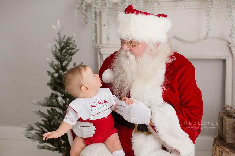 baby toddler looking at Santa in surprise and wonder
