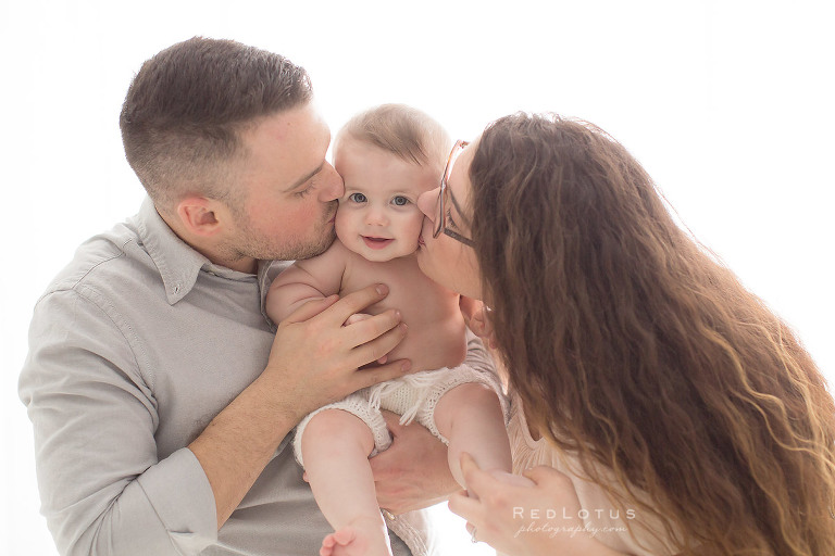 baby kissed by parents mom and dad