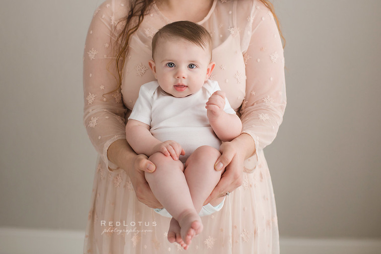 6 month old baby held by mother