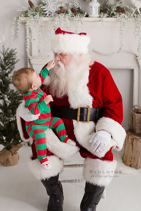 child touching Santa's nose