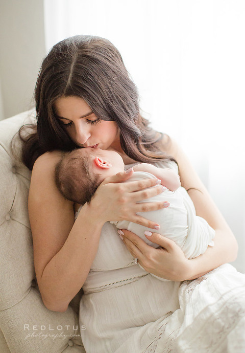 newborn photography mother and child mom kissing baby neutral colors light airy window