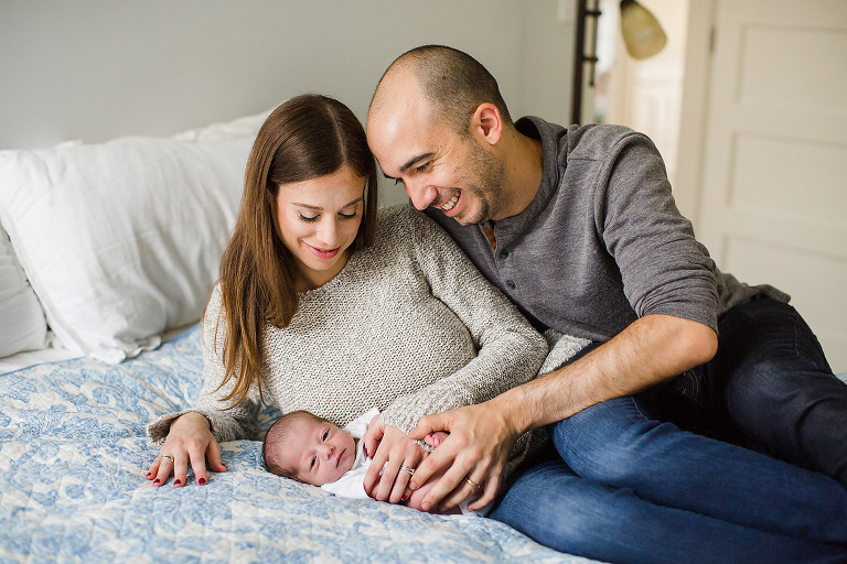 lifestlye newborn photography home session newborn photographer mom dad baby on bed natural pose