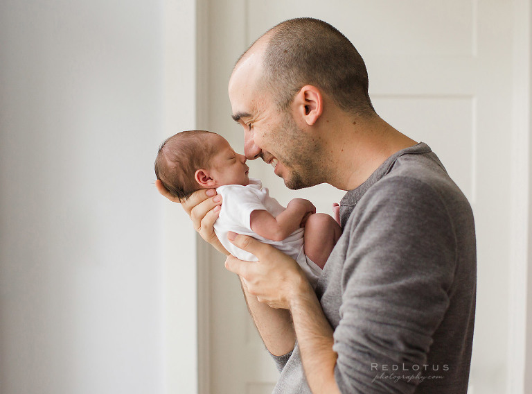 newborn photographer dad holding baby pose Eskimo kiss