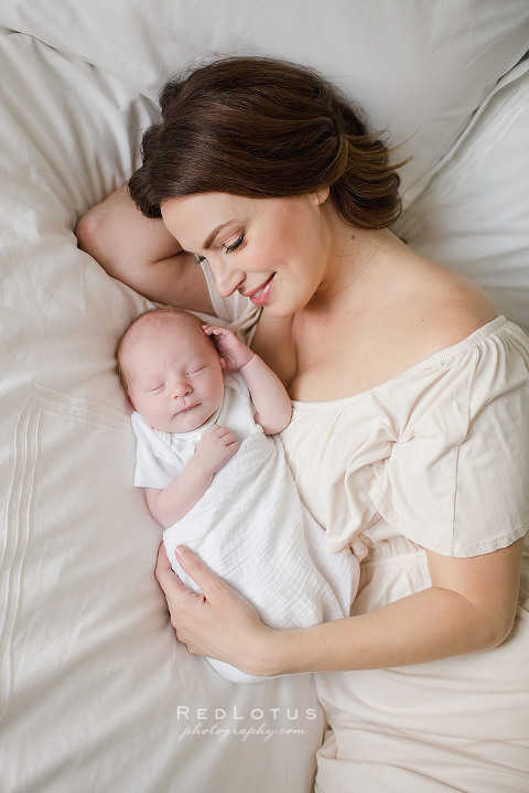 beautiful mother and baby laying on bed