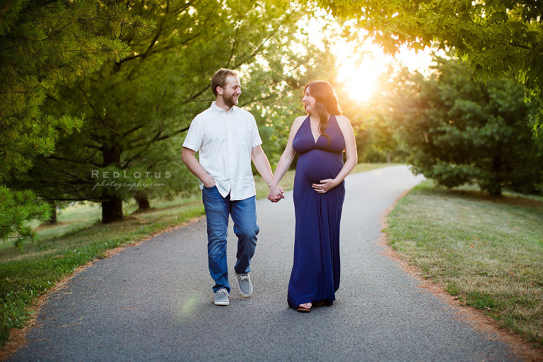 maternity photos couple walking holding hands at sunset happy pregnancy