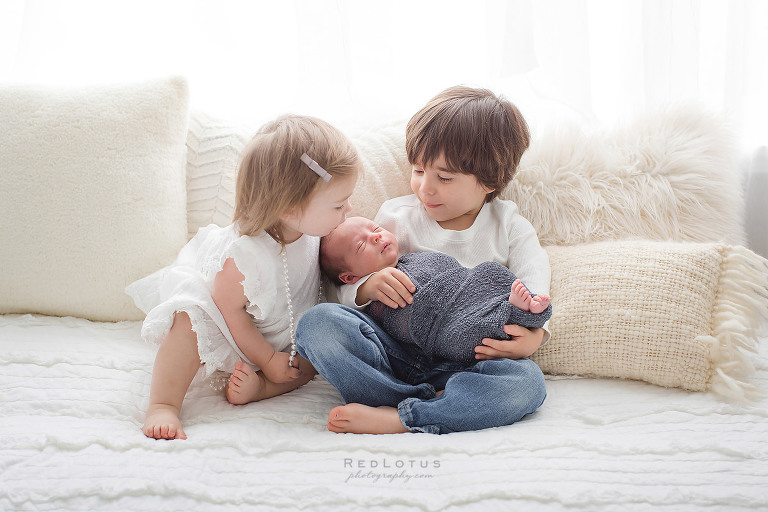 newborn and siblings photography pose baby in basket young children toddlers