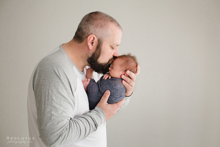 newborn photography dad and baby pose father kissing baby