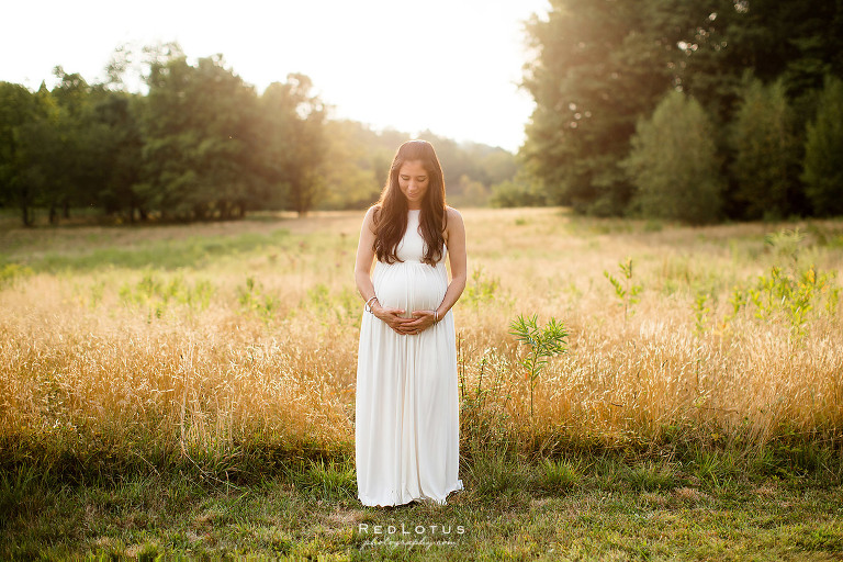 maternity photography pregnancy photos mama holding belly outdoors nature field sunset