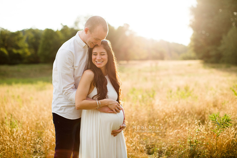 maternity photos Pittsburgh happy couple smiling outdoors field nature sunset white dress
