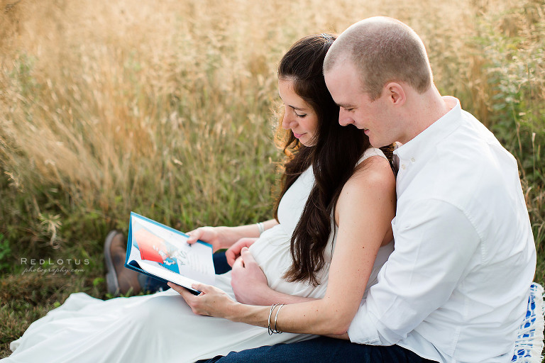maternity poses couple reading baby book together