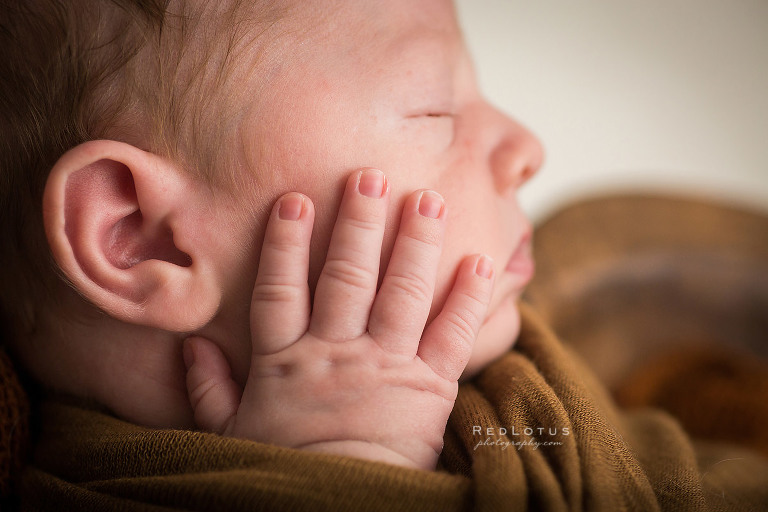 newborn photography details macro baby hand on cheek