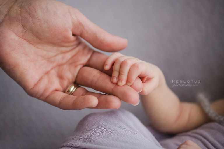 baby hand holding mom's finger