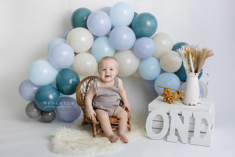 first birthday photos boy with blue balloon garland