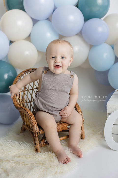 first birthday photos boy with blue balloon garland