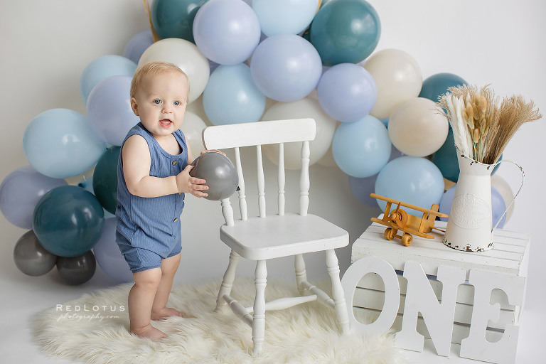 first birthday photos boy with blue balloon garland