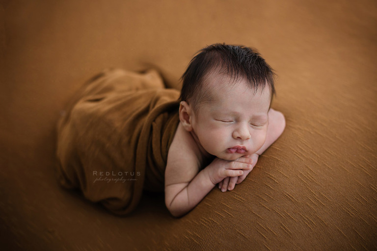 newborn baby boy sleeping on belly pose