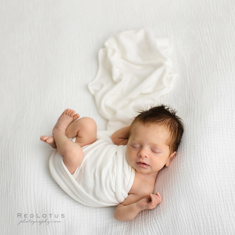 newborn photography baby on white backdrop natural pose