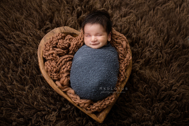 newborn baby wooden heart bowl sleeping and smiling
