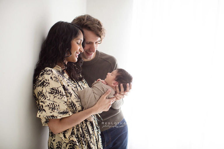 newborn and parents natural pose backlit window light airy studio
