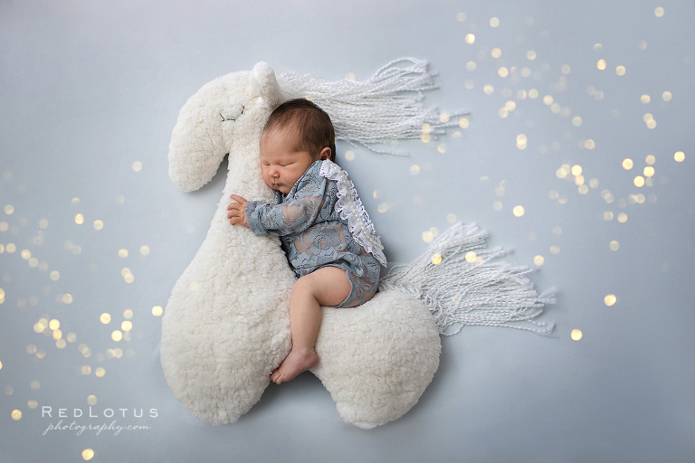 newborn baby girl riding horse with sparkles