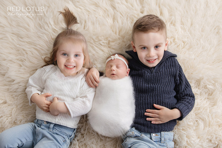 newborn baby posed in a bucket surrounded by white flowers