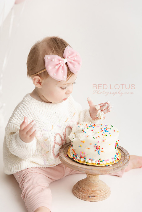one year old toddler girl smashing cake